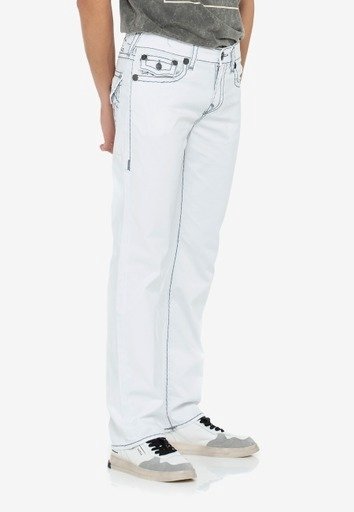 Personne portant un jean blanc droit avec des coutures décoratives et des boutons, associé à des baskets décontractées et une chemise rentrée.
