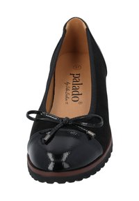 Ballerine nere con tomaia in suede, punta in vernice lucida, fiocco decorativo e suola resistente con un leggero tacco.