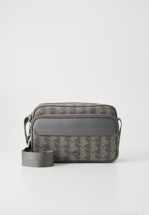 Grå Lacoste taske med geometrisk mønster, to lynlåslommer og justerbar rem. Lavet af tekstureret materiale med logo-detalje.