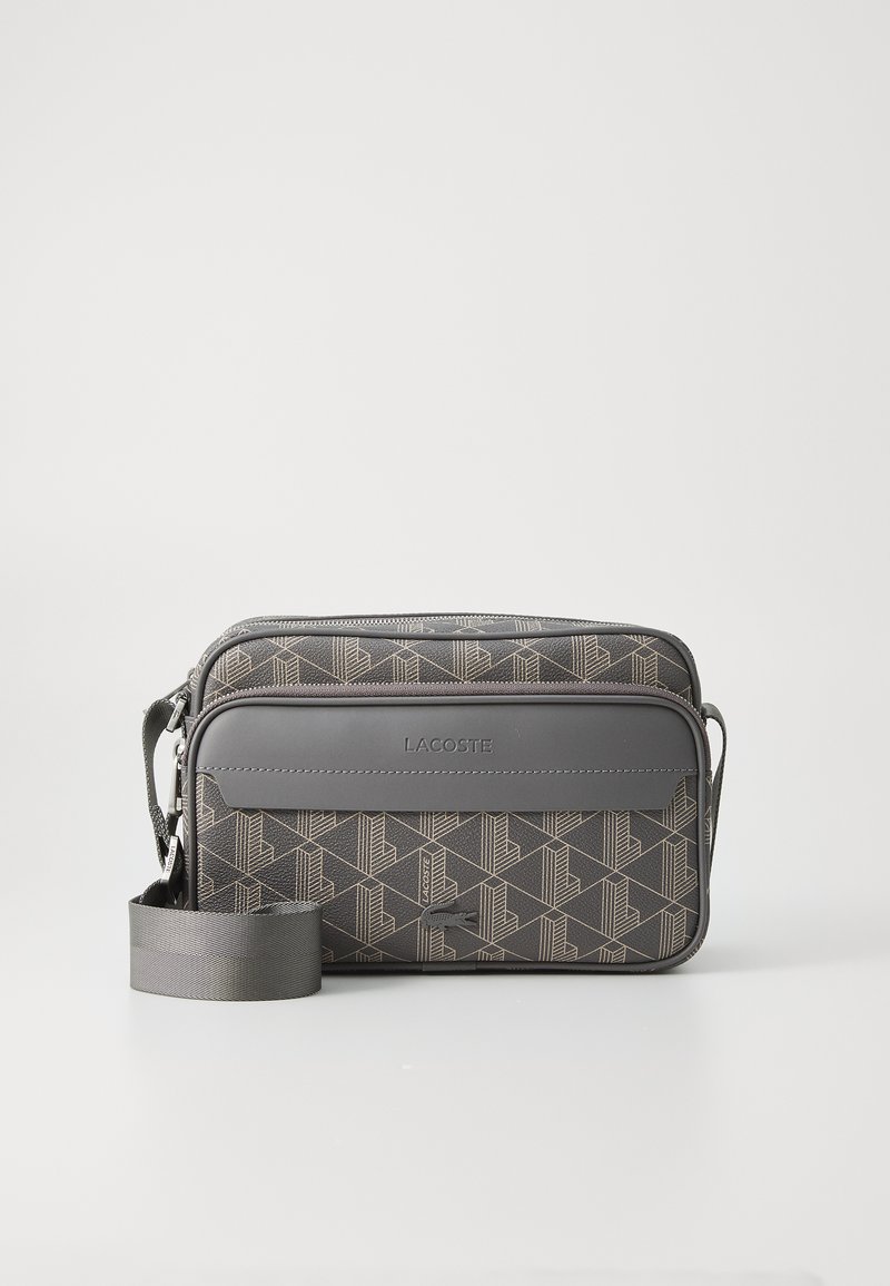 Borsa Lacoste grigia con motivo geometrico, due scomparti con zip e tracolla regolabile. Realizzata in materiale testurizzato con dettaglio del logo.