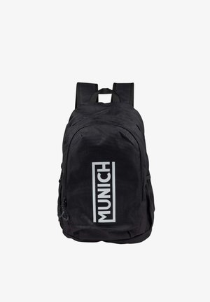 Mochila negra con correas acolchadas, bolsillo frontal con cremallera y logotipo blanco "MUNICH" centrado verticalmente en el compartimento delantero.
