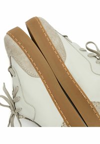 Scarpe in pelle grigio chiaro con suola in gomma color tan, con un accento in suede, lacci rotondi e dettagli di cucitura a contrasto lungo i bordi.