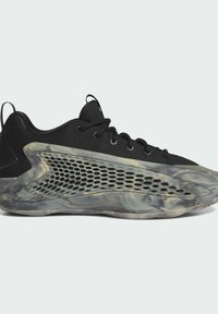 Scarpa sportiva nera con tomaia in rete, design elegante e suola traslucida marmorizzata con fori esagonali per la ventilazione.
