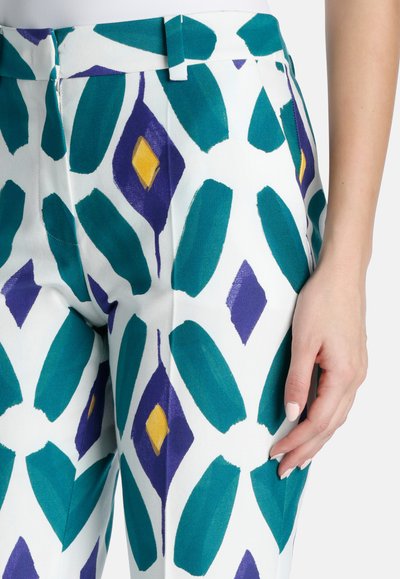 Pantaloni colorati albi cu un model geometric de frunze teal, diamante mov și accente galbene; țesătură netedă; design slim fit.