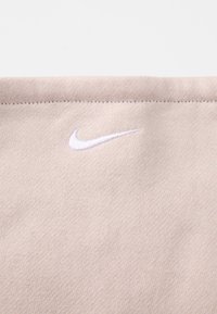 Tecido bege claro com uma textura suave, apresentando um logótipo da Nike em bordado branco na área inferior esquerda.