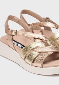Sandales en cuir texturé or et or rose, avec plusieurs brides, boucle réglable et une semelle en plateforme blanche. Doublure intérieure lisse.