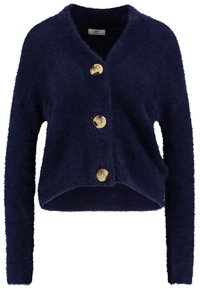 Navy blue cropped cardigan made of fluffy fabric, featuring long sleeves and three large, round, gold-tone buttons at the front.
