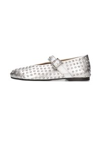 Zapato plano plateado con puntera redondeada, adornado con tachuelas texturizadas y una hebilla lateral. Acabado metálico suave y tacón mínimo.