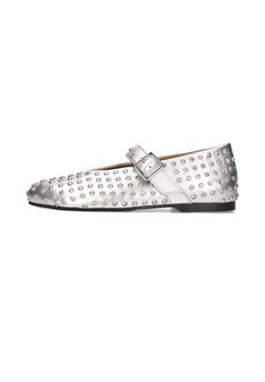 Zapato plano plateado con puntera redondeada, adornado con tachuelas texturizadas y una hebilla lateral. Acabado metálico suave y tacón mínimo.