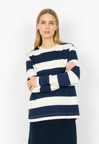 Tumesiniste ja kreemika triibuga pikkade varrukatega särk ümmarguse kaelusega. Pehme materjal, lõdvestunud istuvus, nähtav õmblusääre ja mansettide ääres.