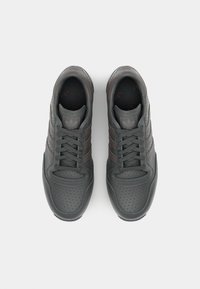 Σκούρες γκρι αθλητικές μπότες με διάτρητη υφή, τρία καφέ ρίγες, σχέδιο με κορδόνια, στρογγυλή μύτη και μια διακριτική λογοτύπηση στην γλώσ�σα.