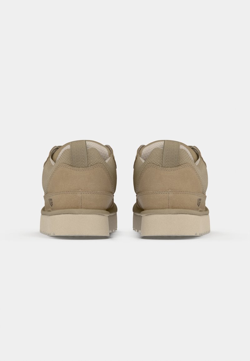 Beige Turnschuhe mit Obermaterial aus Wildleder und Mesh, ausgestattet mit einem gepolsterten Schaft und einer strukturierten, hellen Gummisohle. Einfaches Design mit minimalen Akzenten.