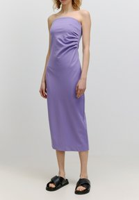 Paarse, strapless maxi-jurk met geplooide textuur op de zijkant. Gekocht met zwarte instapsandalen. Soepele stof en slimfit silhouet.
