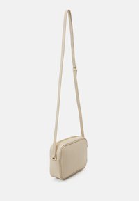 Borsa a tracolla beige con texture liscia, forma rettangolare, singolo manico regolabile e dettagli in metallo dorato sulla zip.