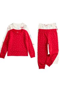 Rød langærmet top med hvide prikker, parret med hvide mønstrede bukser med festlige motiver. Blødt bomuldsstof, elastisk linning.