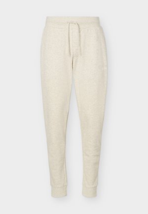 Lichtbeige joggingbroek met koordsluiting in de taille en omslag bij de enkels, gemaakt van zacht, gestructureerd stof.