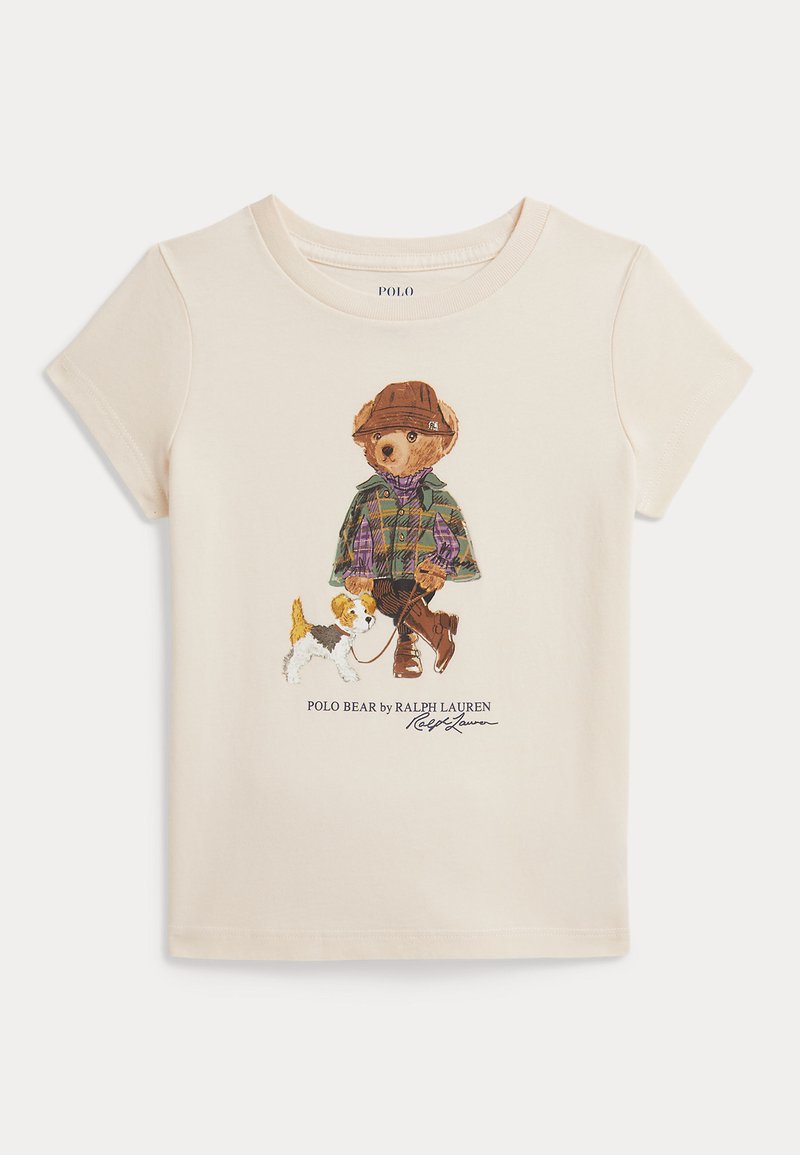 T-shirt σε κρεμ χρώμα με τυπωμένη αρκούδα που φοράει καπέλο και πουκαμίσα σε καρό μοτίβο και περπατάει ένα μικρό σκυλί, με το κείμενο "Polo Bear by Ralph Lauren" από κάτω.