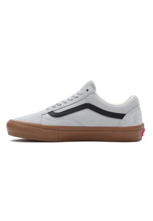 Sneaker in tela grigia con una striscia nera, dettagli bianchi e suola in gomma marrone. Caratterizzato da lacci rotondi e design a bassa altezza.