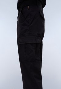 Black cargo pants with a relaxed fit, featuring large side pockets and a waistband with adjustable hardware for a customizable fit.
