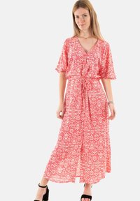 Vestido maxi en rojo con un patrón abstracto blanco. Escote en V, mangas cortas tipo volantes y cintura ajustable. Tejido fluido con un corte relajado.