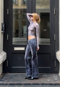 Sheer long-sleeve top with a textured dark floral pattern, paired with high-waisted gray wide-leg velvet pants and pointed black flats.