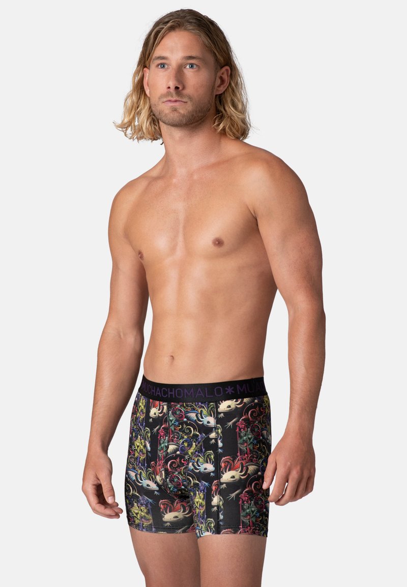 Boxer in tessuto nero con motivi grafici colorati e dettagliati. Vita elasticizzata con logo "MUCHACHO MALO" in viola.