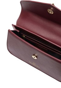 Borsa in pelle color bordeaux con finitura texturizzata, ferrature dorate, tasca interna con cerniera e chiusura a scatto magnetico. Presenta un logo del marchio.