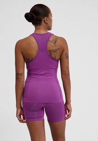 Purple athletic tank top with a breathable mesh back, paired with matching shorts, featuring a smooth texture and form-fitting design.