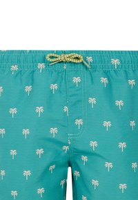 Costume da bagno turchese con un motivo ripetuto di palme bianche. Vita elastica con un cordoncino intrecciato giallo e nero.