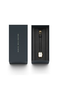 Gold-colored rectangular watch with a white face, black leather strap, displayed in a dark blue box with a soft interior lining.