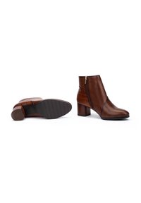 Bottines en cuir marron avec un motif crocodile texturé, fermeture éclair latérale, talon carré et semelle en caoutchouc avec un motif antidérapant.