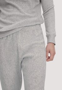 Grau Sweatshirt und passende Jogginghose aus weichem, strukturiertem Stoff. Die Hose verfügt über einen elastischen Bund und seitliche Taschen.
