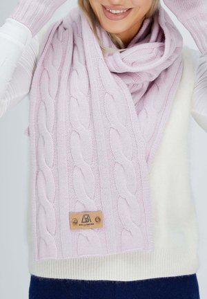 Sciarpa rosa lavorata a maglia con design a treccia, un'etichetta in pelle, e una texture morbida, avvolta attorno a un maglione bianco.