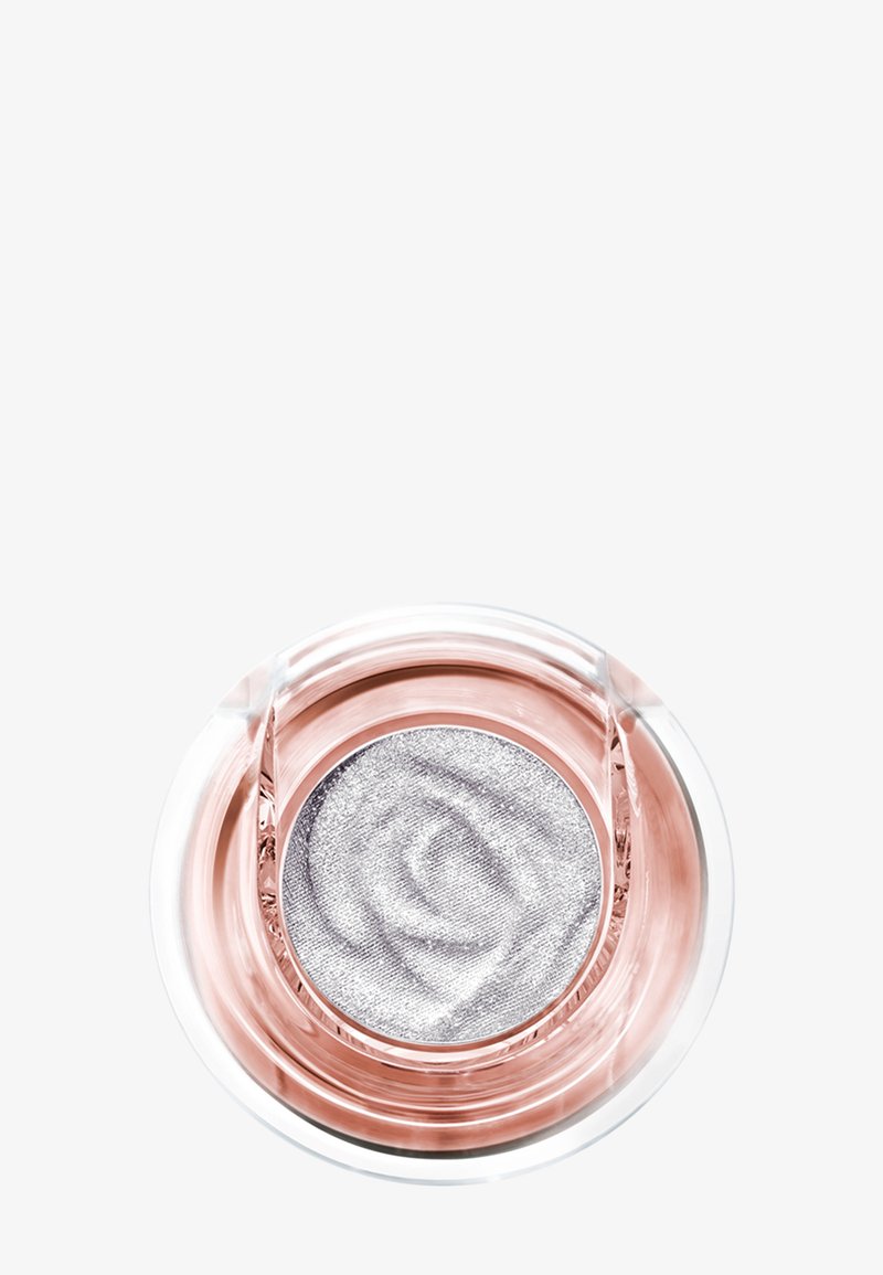 Contenant en verre rond renfermant une ombre à paupières crème argentée scintillante avec une texture tourbillonnante subtile, posé sur un fond blanc.