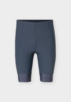 Pantalones cortos de ciclismo acolchados de color gris oscuro con piernas hasta la rodilla y dobladillos reforzados sobre un fondo blanco.