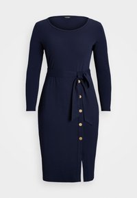 Marineblauwe jurk met lange mouwen, een ronde hals, een stoffen strik in de taille en goudkleurige knopen langs de zijsplit voor extra detail.
