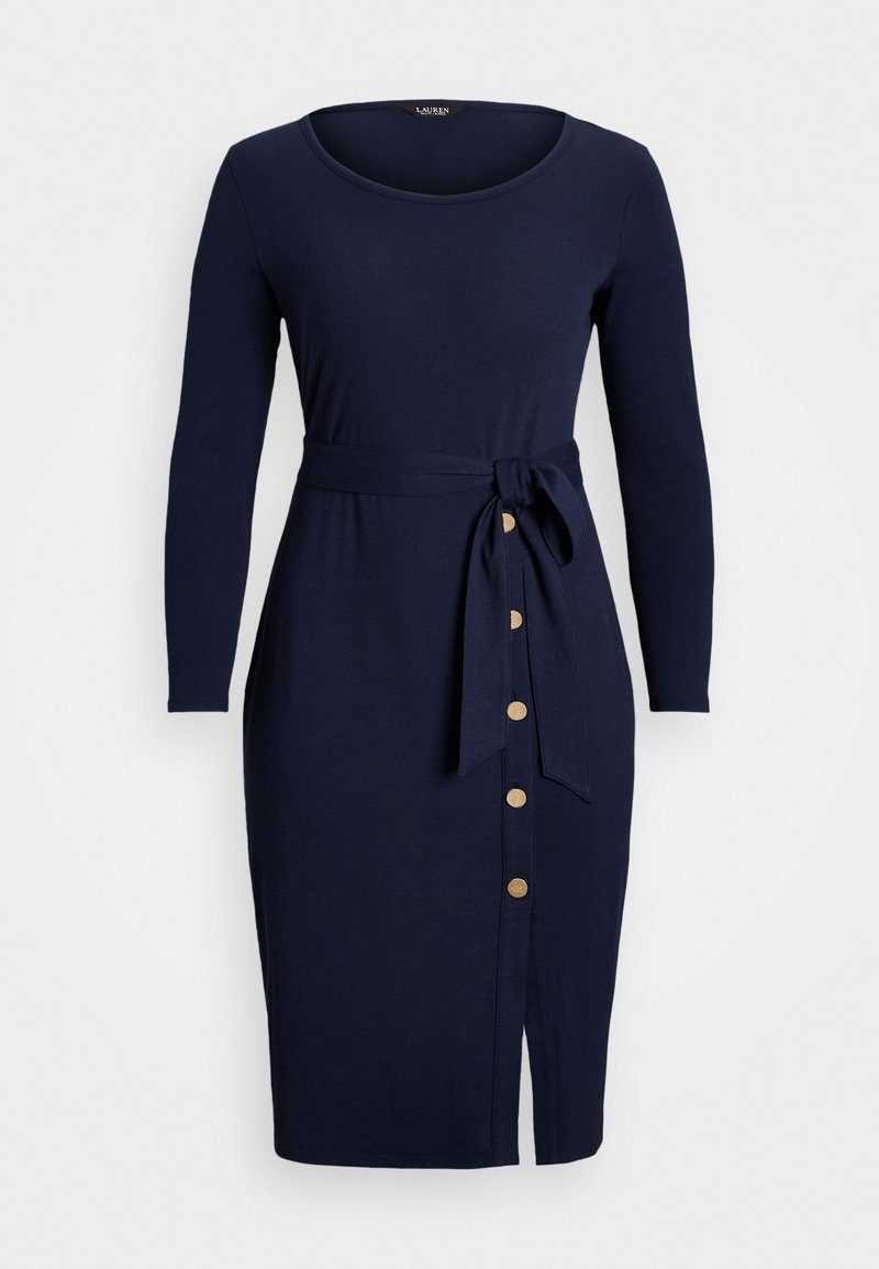 Marineblauwe jurk met lange mouwen, een ronde hals, een stoffen strik in de taille en goudkleurige knopen langs de zijsplit voor extra detail.