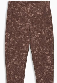 Leggings marron en matière texturée avec un motif moucheté. Taille haute et un petit logo sur le côté inférieur.