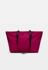 Grand sac fourre-tout magenta avec des bretelles noires, présenté sur un fond clair uni.