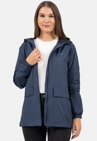 Marineblauwe lichtgewicht jas met een capuchon, elastische manchetten en twee voorzakken, gemaakt van een gladde, waterafstotende stof.