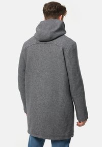 Cappotto in misto lana grigio con colletto alto e silhouette morbida, maniche lunghe e design a mezza lunghezza per il massimo calore.