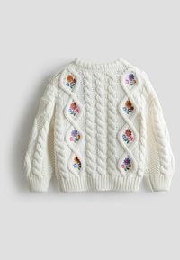 Off-White Strickpullover mit Kabelstrickmuster und floraler Stickerei auf rautenförmigen Ausschnitten an den Seiten. Rundhalsausschnitt.