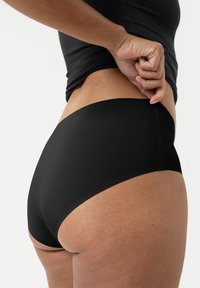 Zwarte bikinionderkant zijaanzicht, uitgevoerd in een zachte, rekbare stof met een middellange snit, dat een bijpassend zwart topje aanvult.