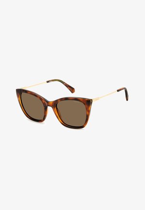 Occhiali da sole a forma di occhio di gatto in tartaruga con lenti marroni, aste in metallo dorato e una finitura verde all'interno del tempio. Texture liscia con una finitura lucida.