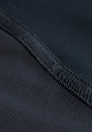 Prim-plan al unui material închis la culoare cu o textură netedă și o cusătură care străbate diagonal cadrul.