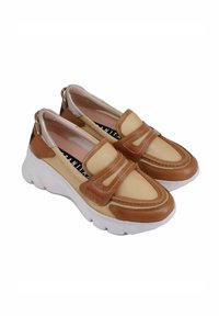 Scarpe slip-on beige e marroni con tomaia in tessuto strutturato, decorazioni cucite e una robusta suola in gomma bianca. Presentano un collo imbottito.