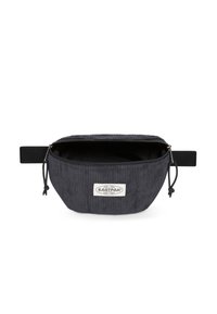 Borsa a vita in corduroy nera con zip aperta, cinturino regolabile nero e patch del logo Eastpak bianco sul davanti.