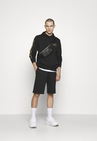 EA7 Emporio Armani BERMUDA - Pantalones deportivos - black/gold-coloured