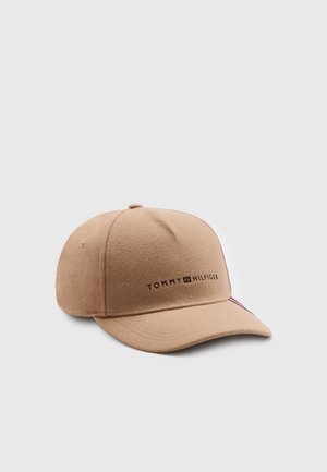 Casquette de baseball beige Tommy Hilfiger avec une visière incurvée et le nom de la marque brodé centré sur la partie avant sur un fond uni.
