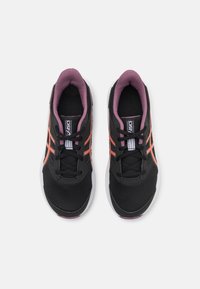 Baskets de sport noires avec des accents roses, tige en mesh, bout rond et semelle blanche contrastante. Comprend des lacets et un logo sur la languette.